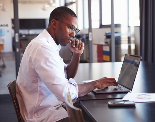 African American Man Working at Desk with Laptop